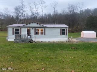 view of front facade featuring a front yard and an outbuilding