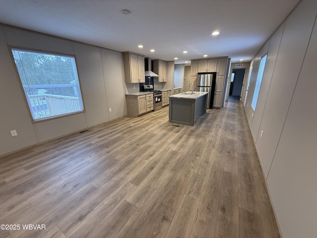 kitchen featuring stainless steel appliances, sink, wall chimney range hood, gray cabinets, and a kitchen island