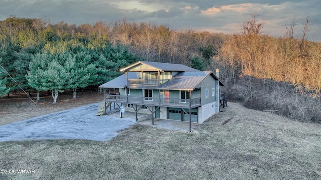 back house at dusk featuring a wooden deck and a garage