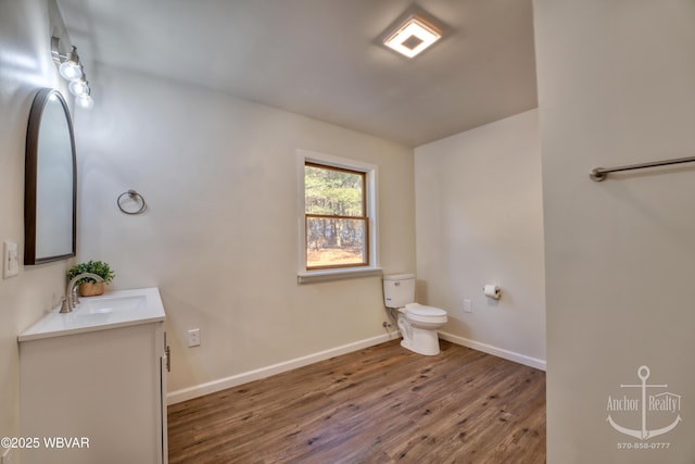 bathroom with hardwood / wood-style flooring, vanity, and toilet