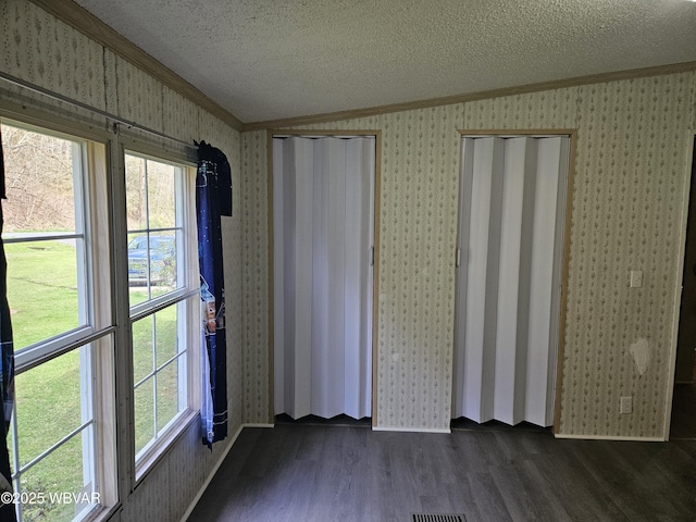 1592 Cement Hollow Rd, Jersey Shore, PA 17740 - unfurnished room featuring a textured ceiling, dark wood finished floors, vaulted ceiling, wallpapered walls, and ornamental molding