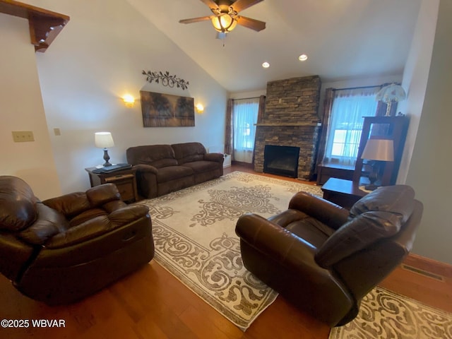 living room featuring ceiling fan, plenty of natural light, wood-type flooring, and a fireplace