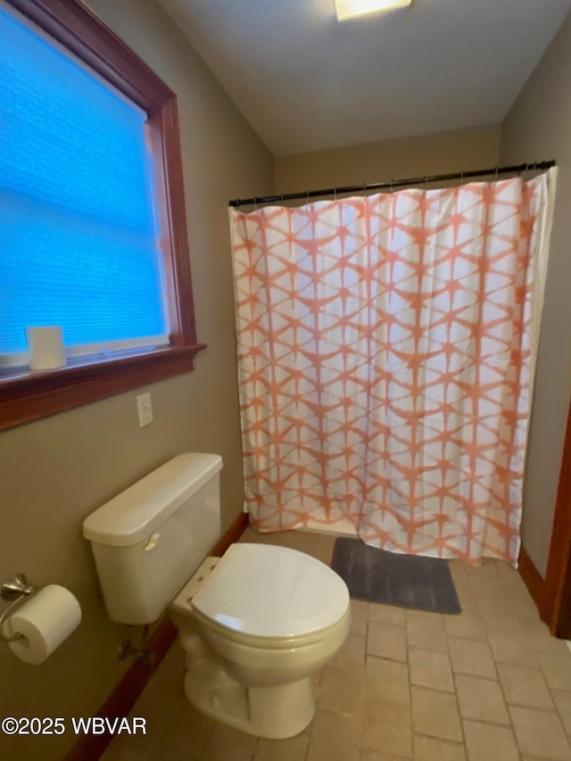 bathroom with toilet, a shower with curtain, and tile patterned flooring