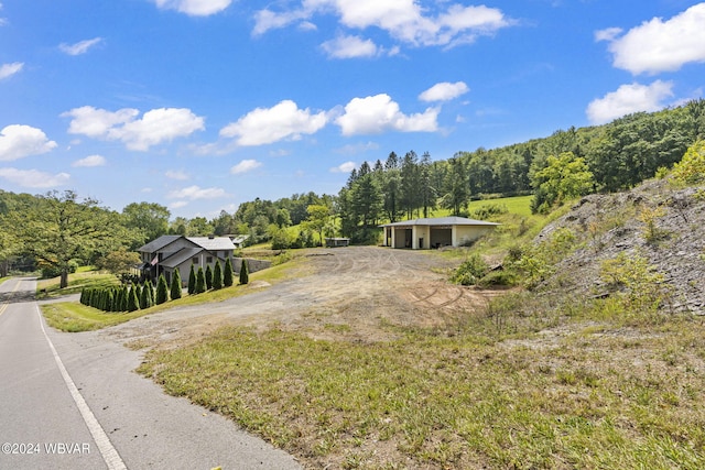 view of front of home with driveway and a forest view