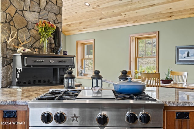 kitchen featuring wood ceiling, vaulted ceiling, stove, and brown cabinets