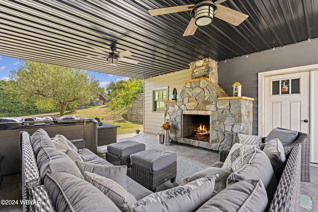 living area with plenty of natural light, wood walls, ceiling fan, and an outdoor stone fireplace