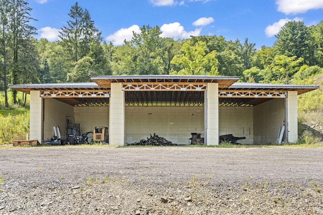 view of car parking with driveway and a pole building