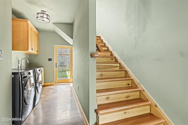 stairway featuring finished concrete floors, washing machine and dryer, and baseboards