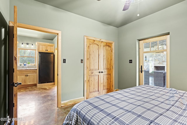 bedroom featuring freestanding refrigerator, a sink, ceiling fan, concrete flooring, and baseboards