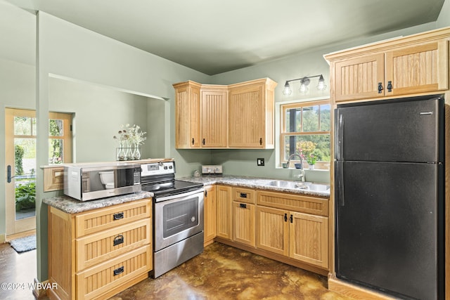 kitchen featuring appliances with stainless steel finishes, light brown cabinets, a sink, concrete floors, and a peninsula