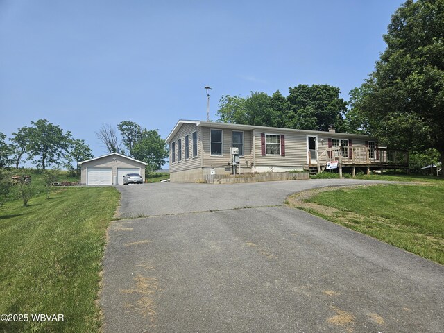 93 Woodside Rd, Danville, PA 17821 - manufactured / mobile home featuring an outdoor structure, a detached garage, a front yard, and a wooden deck