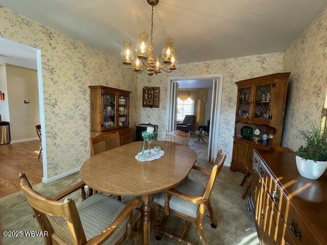 dining area featuring carpet and an inviting chandelier