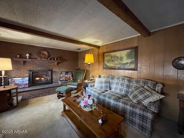 carpeted living room with beamed ceiling, a fireplace, and wooden walls