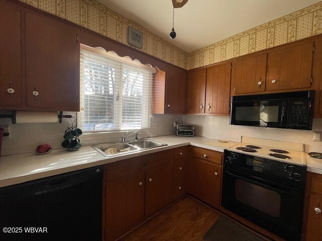 kitchen featuring dark wood-type flooring, sink, and black appliances