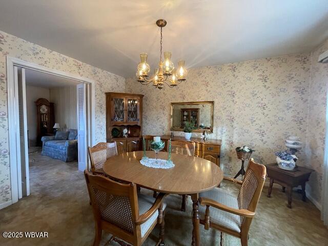 carpeted dining room featuring a notable chandelier