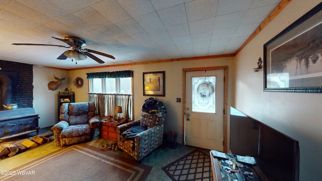 carpeted foyer with ceiling fan, ornamental molding, and a wood stove