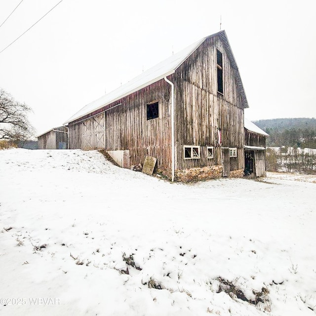 snow covered property with an outdoor structure