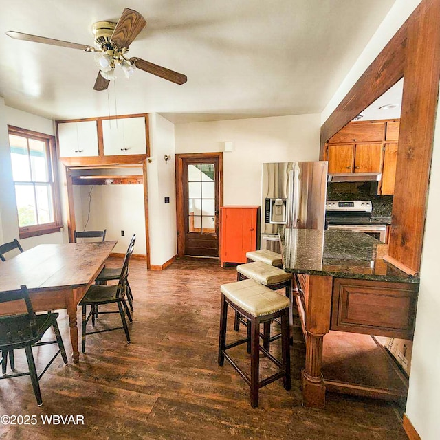 kitchen with ceiling fan, appliances with stainless steel finishes, dark hardwood / wood-style floors, and decorative backsplash