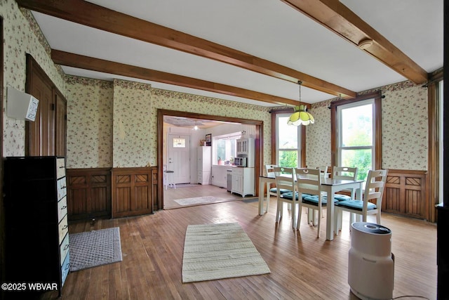 2177 N Williamson Rd, Covington, PA 16917 - dining space with wallpapered walls, a wainscoted wall, beam ceiling, and light wood finished floors
