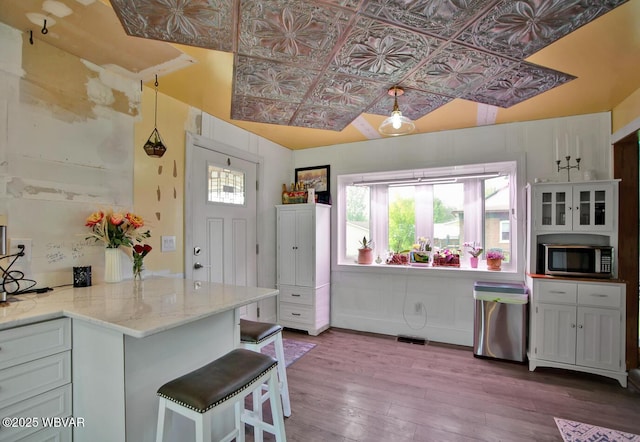 2177 N Williamson Rd, Covington, PA 16917 - kitchen with stainless steel appliances, an ornate ceiling, dark wood-style flooring, a kitchen bar, and light stone counters