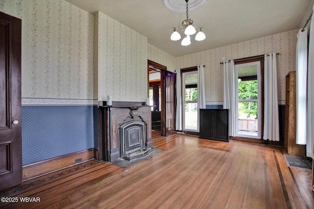 2177 N Williamson Rd, Covington, PA 16917 - unfurnished living room with wallpapered walls, wood finished floors, and a chandelier