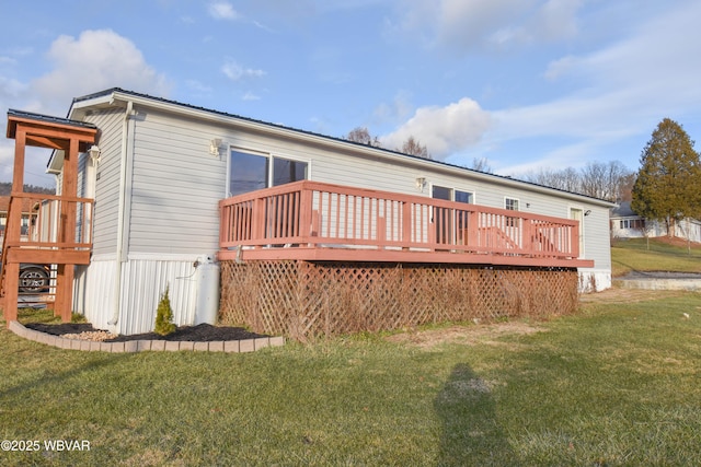 rear view of house featuring a lawn and a deck