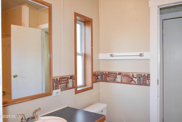 bathroom with toilet, sink, and a wealth of natural light