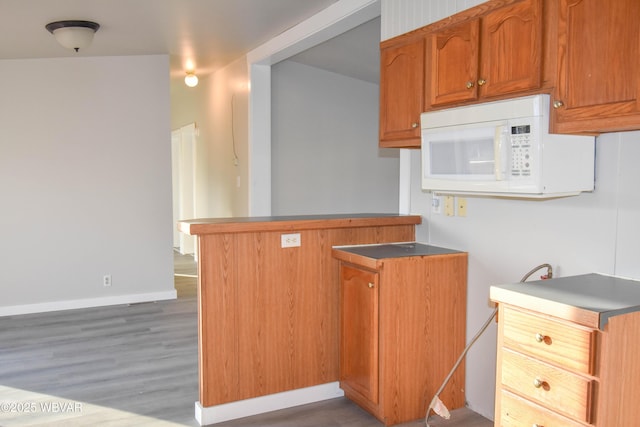 kitchen with kitchen peninsula and hardwood / wood-style flooring