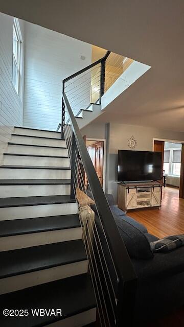 stairway featuring vaulted ceiling and wood finished floors