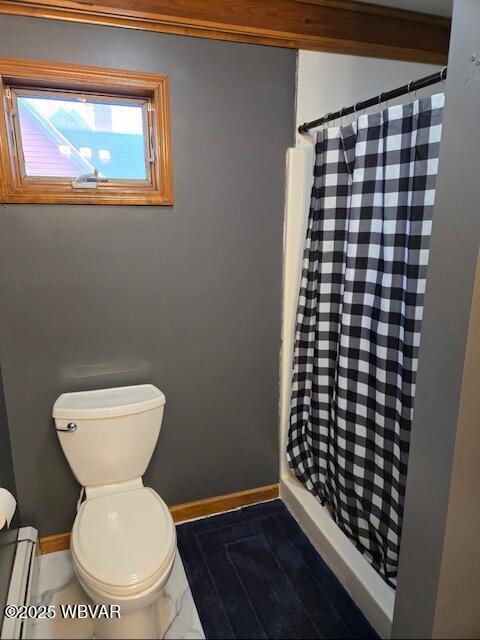 full bath featuring toilet, a shower stall, baseboards, and baseboard heating