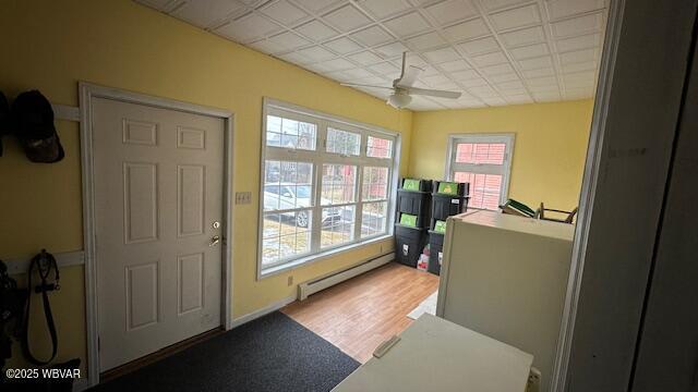 entryway featuring a baseboard radiator, a ceiling fan, and wood finished floors