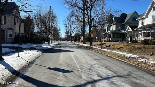 view of street with curbs, traffic signs, sidewalks, and a residential view