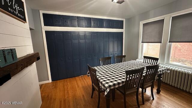 dining area with radiator and wood finished floors