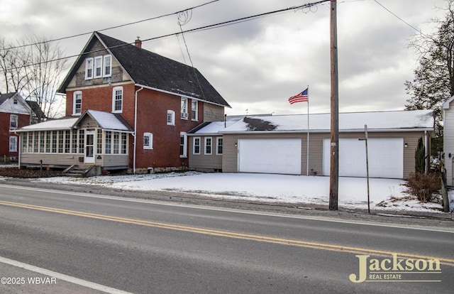 view of front of property with a garage and a sunroom