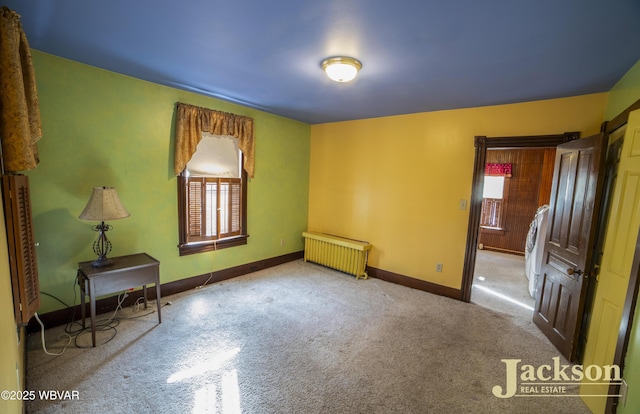 empty room featuring radiator and carpet flooring