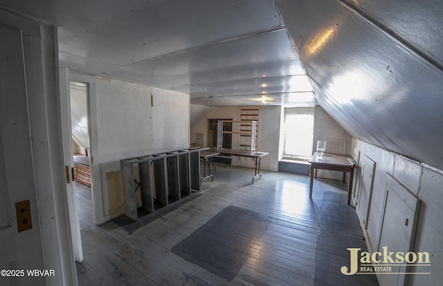 additional living space with hardwood / wood-style flooring and lofted ceiling