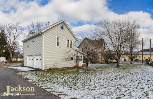 snow covered property featuring a garage