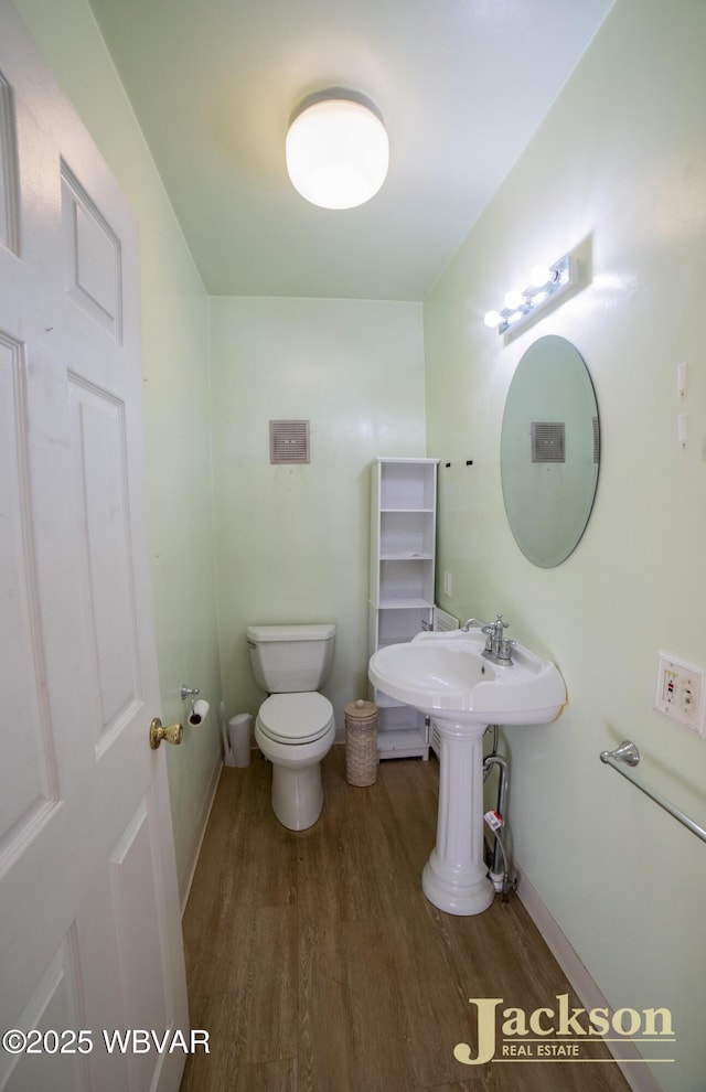 bathroom with wood-type flooring and toilet