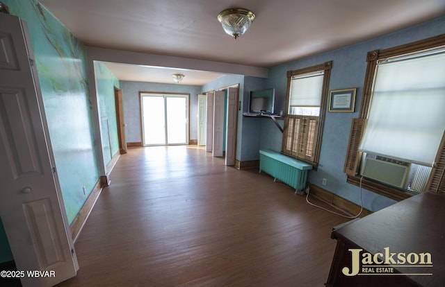 corridor with radiator, cooling unit, and wood-type flooring