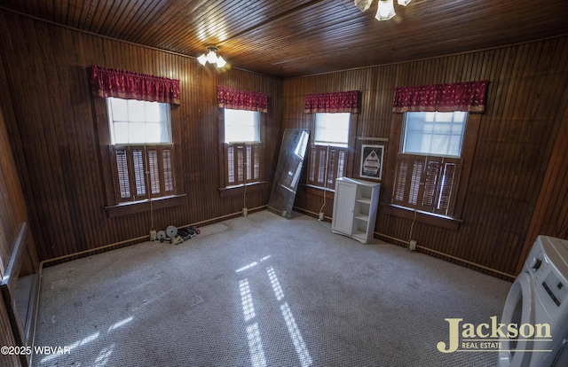 unfurnished room with wooden ceiling, carpet, and wooden walls