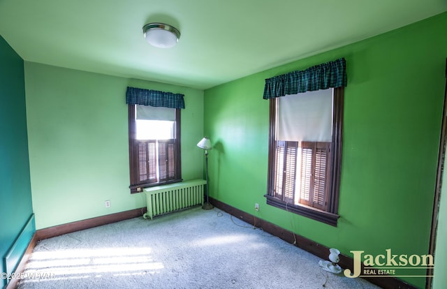 empty room with carpet floors and radiator heating unit