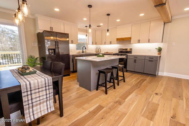 kitchen featuring stainless steel appliances, gray cabinets, light countertops, and white cabinetry