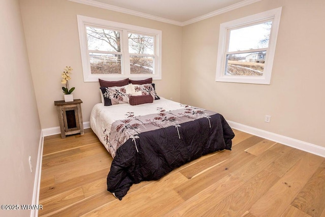 bedroom with multiple windows, baseboards, and wood finished floors