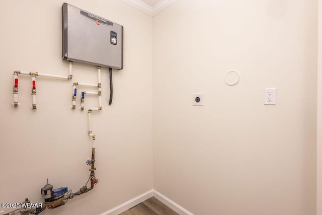 laundry area featuring water heater, hookup for an electric dryer, wood finished floors, laundry area, and baseboards