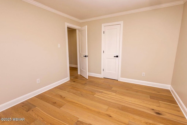 spare room with baseboards, wood finished floors, and ornamental molding