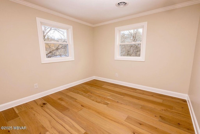 unfurnished room featuring a wealth of natural light, wood finished floors, visible vents, and baseboards