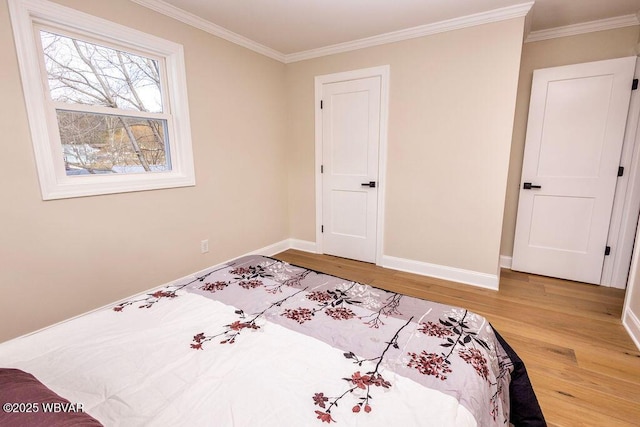 bedroom featuring crown molding, wood finished floors, and baseboards