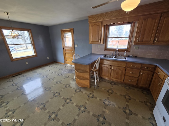 kitchen featuring a wealth of natural light, backsplash, open shelves, and a sink