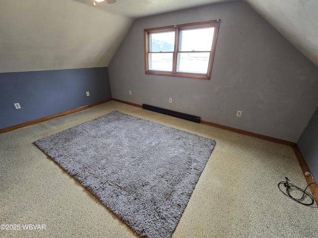 additional living space featuring vaulted ceiling, baseboards, and a baseboard radiator