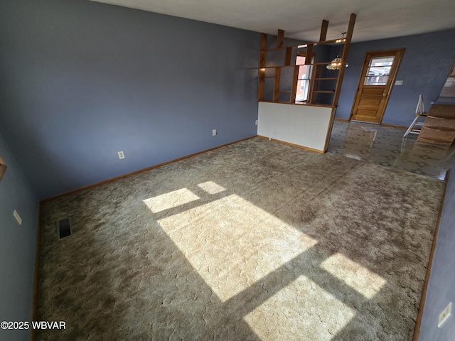 spare room featuring visible vents, baseboards, and carpet flooring